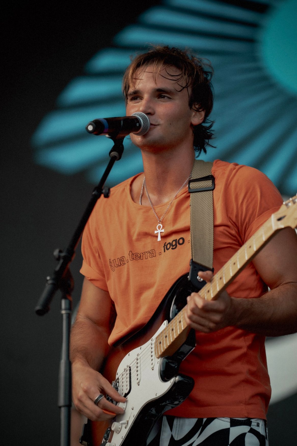 Marco smiling at the mic with his guitar